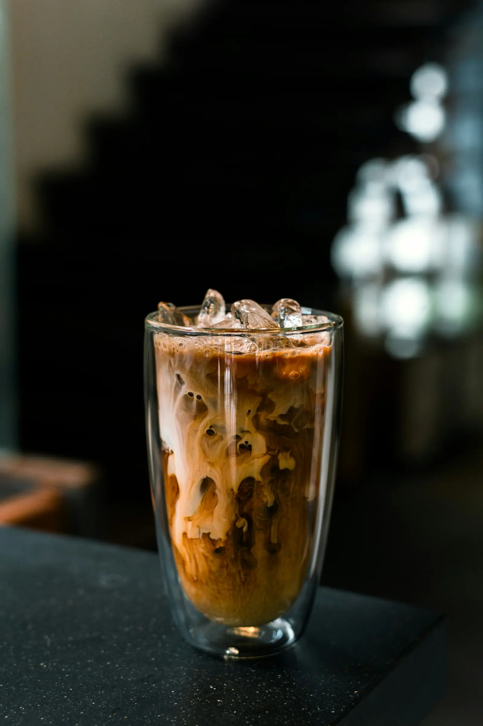 Cold Brew mit Sahnewirbel auf Eis in einem hohen doppelwandigen Glas